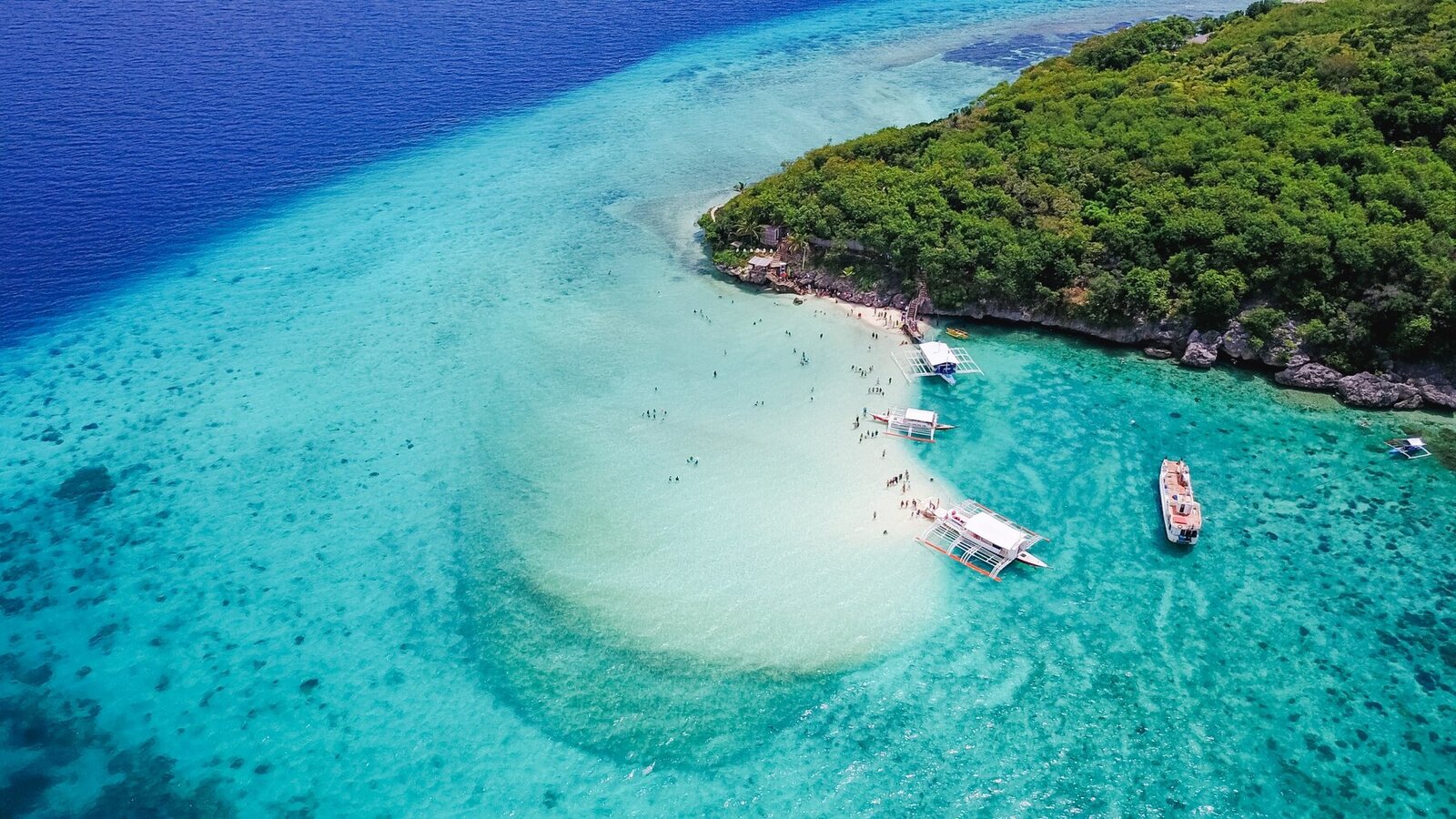 Liveaboards anchored off a white sand beach, Indonesia