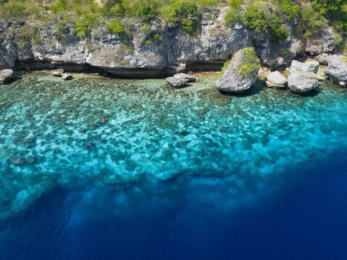 Clear reef shallows below limestone cliffs, Dai and Babar